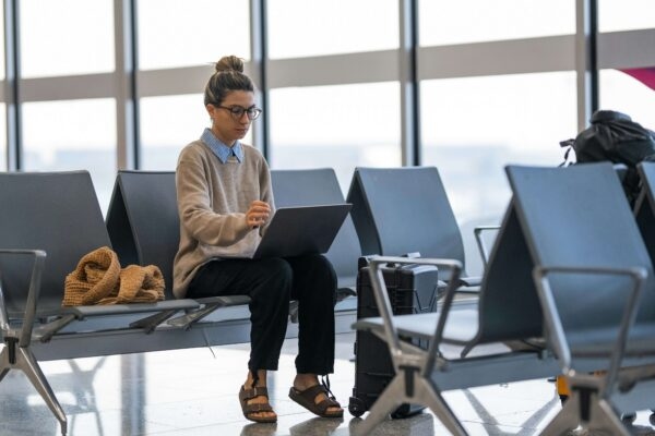 Woman in airport working on laptop