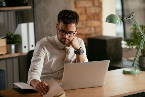 Man flicking through notebook at desk